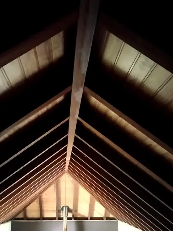 Estructura de cubierta a dos aguas con vigas de madera vistas
